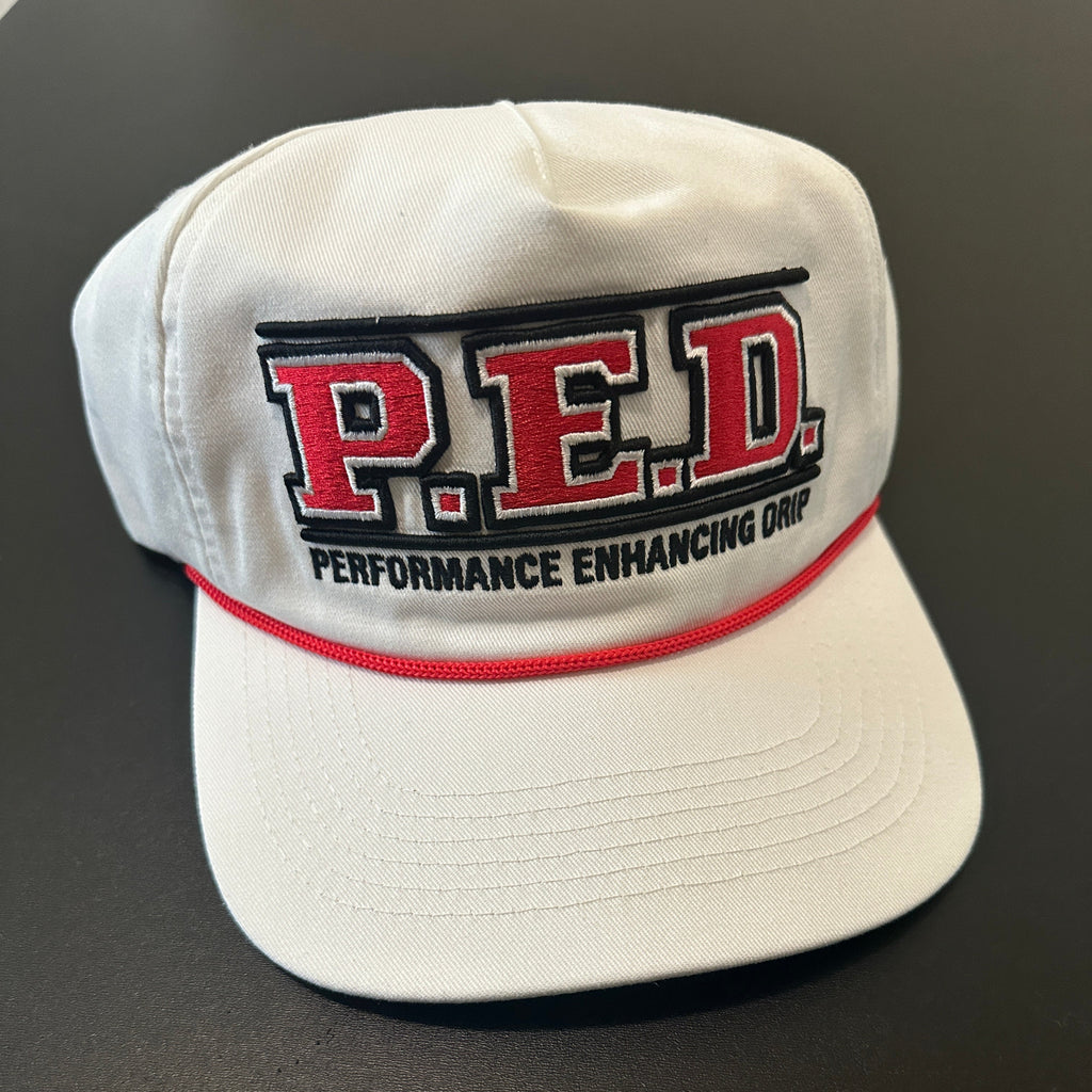 White cap with red and black 'P.E.D.' logo on a dark background
