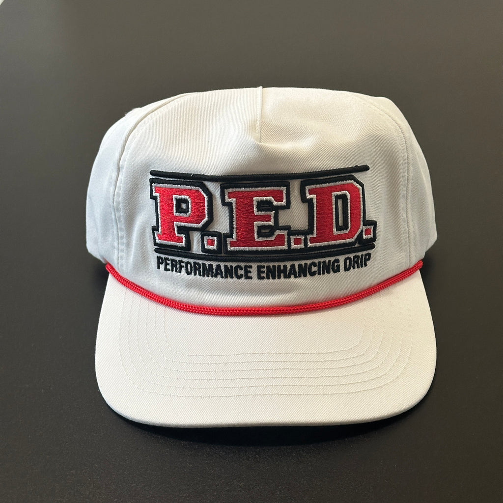 White cap with 'P.E.D. Performance Enhancing Drip' text on a dark background
